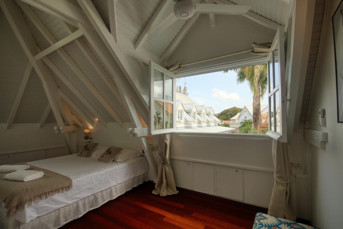 12-Location-appartement-trois-ilets-martinique-chambre-1-fenêtre-vue-village